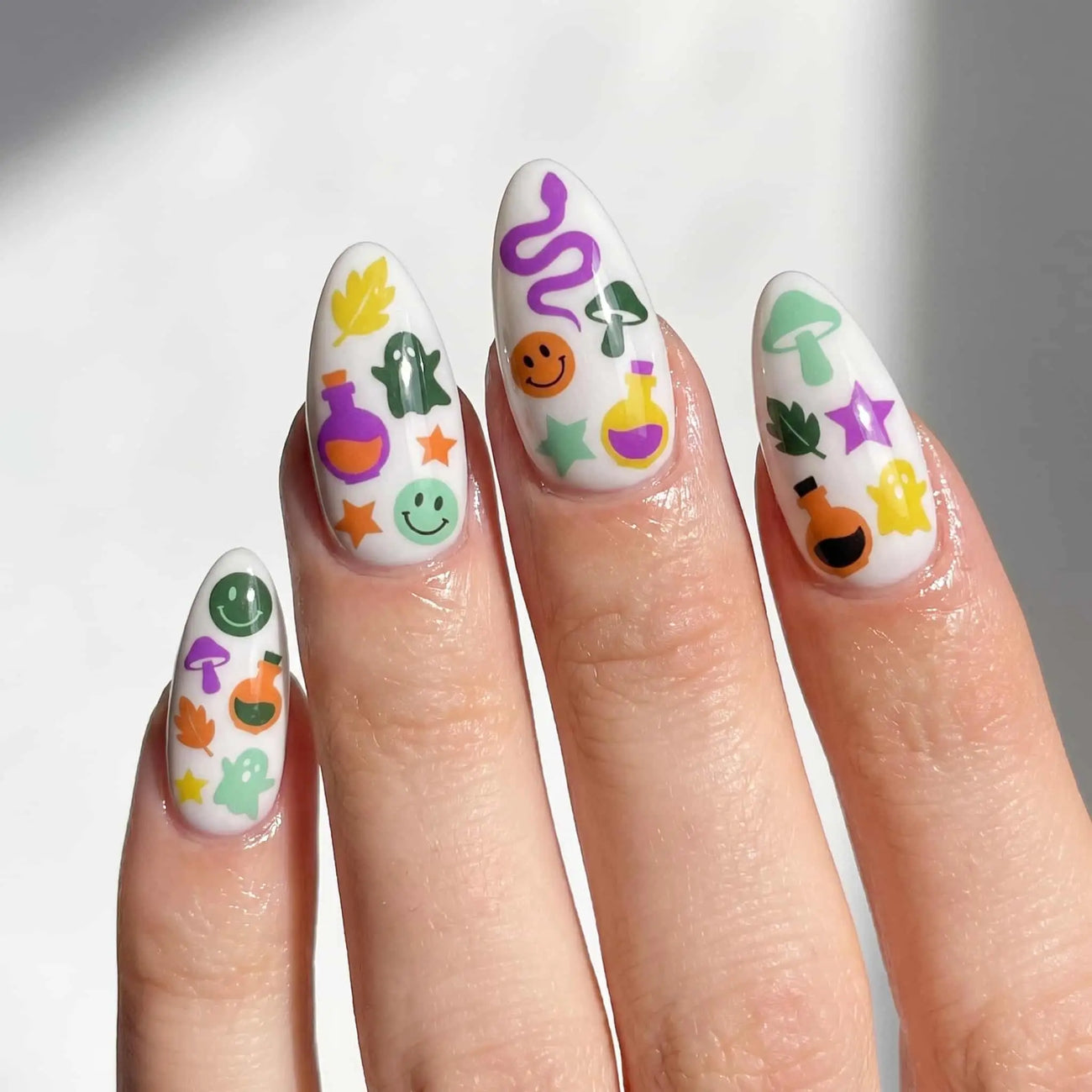 halloween almond press on nails worn look, pastel snake, ghost, and pumpkin