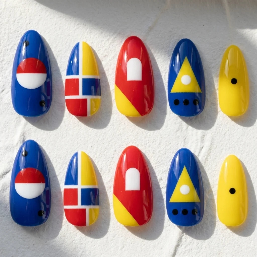 Primary Pop short almond press-on nails — red, blue, and yellow geometric color blocks