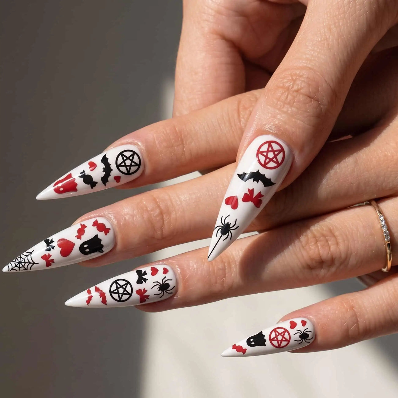 halloween stiletto press on nails worn look, red hearts, bows, bats, and pentagrams