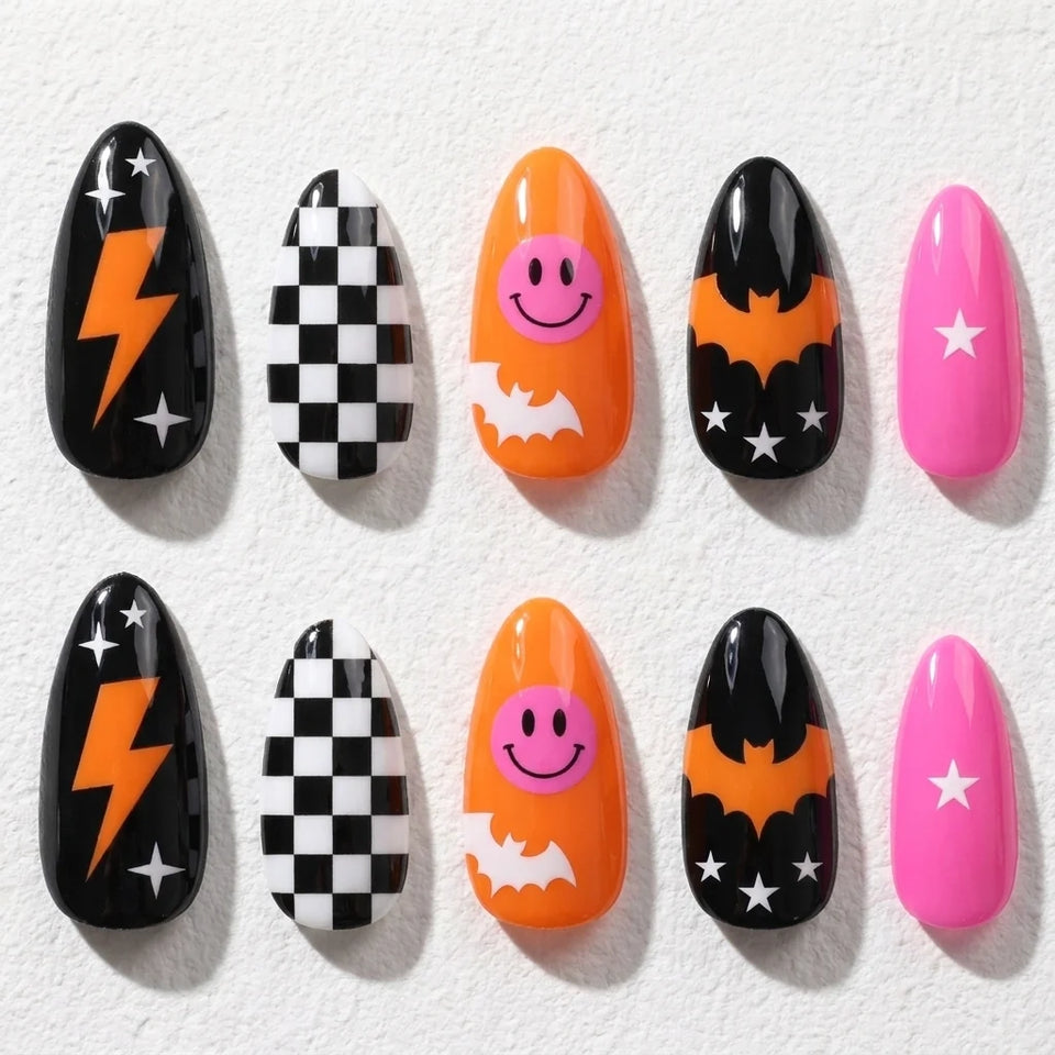 Bat Bolt short almond press-on nails — bats, lightning, checkerboard, and a smiling orange accent