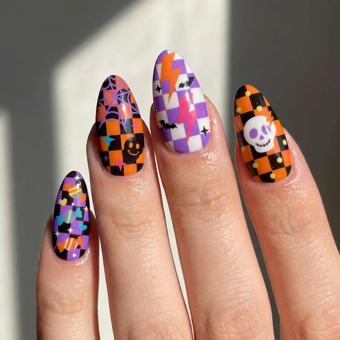 halloween almond press on nails worn look, orange and purple patchwork with skulls and spider webs