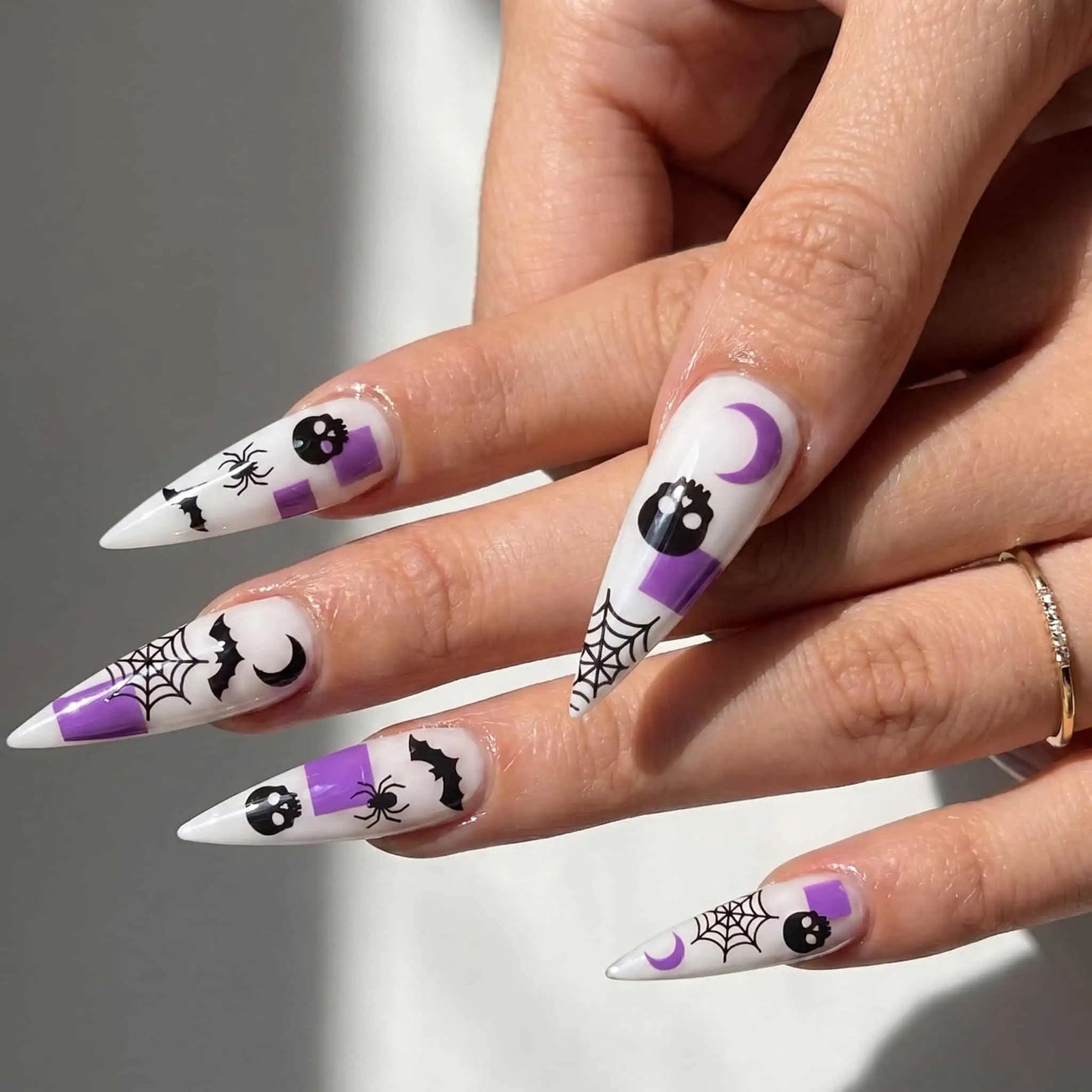 halloween stiletto press on nails worn look, purple skulls, bats, and spider webs